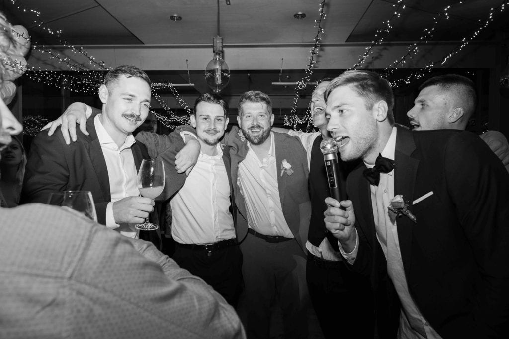 Freunde feiern Hochzeit, lachend und anstoßend, festliche Atmosphäre, Hochzeitsfeier, glückliche Mom.