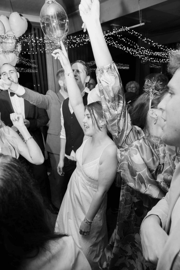 Menschen tanzen und feiern auf einer Hochzeitsparty, festliche Stimmung, Ballons und Lichterdekorati.