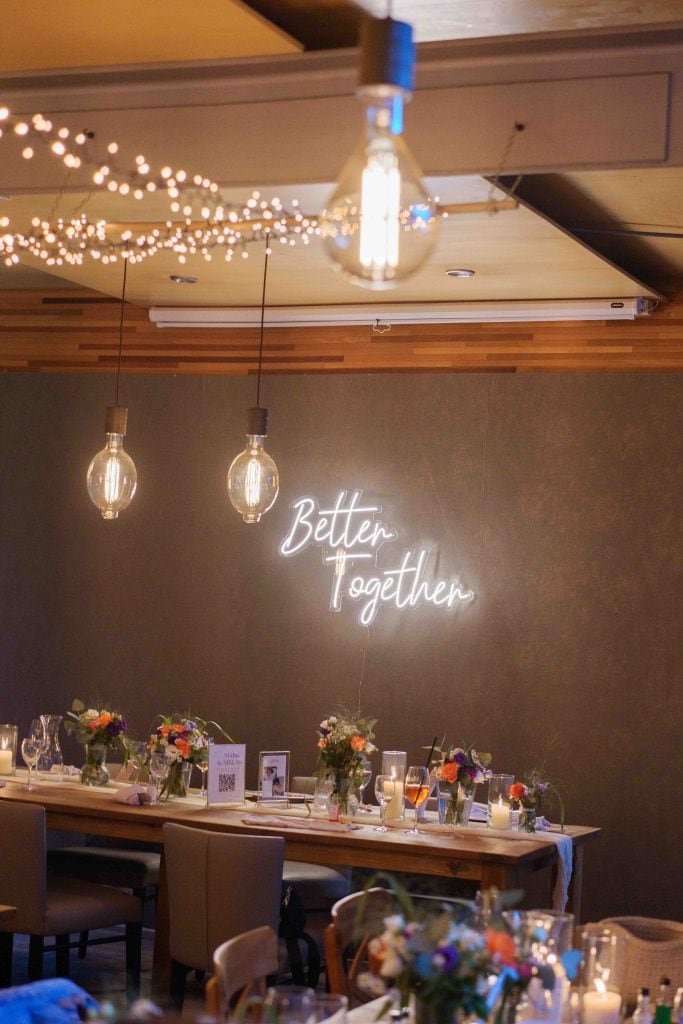 Eleganter Veranstaltungsraum mit dekorativem Licht und Blumenarrangements.