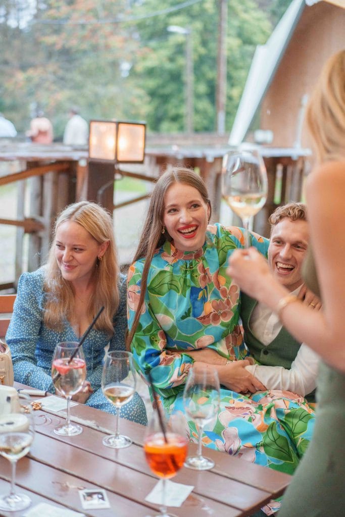 Fröhliche Menschen beim gemeinsamen Dinner im Freien, lachend und in Gespräche vertieft, bei schönem.