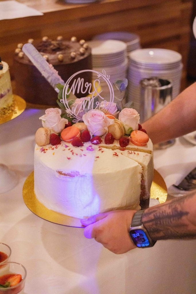 Hochzeitstorte mit Blumen, Macarons und "Mr & Mrs" Dekoration.