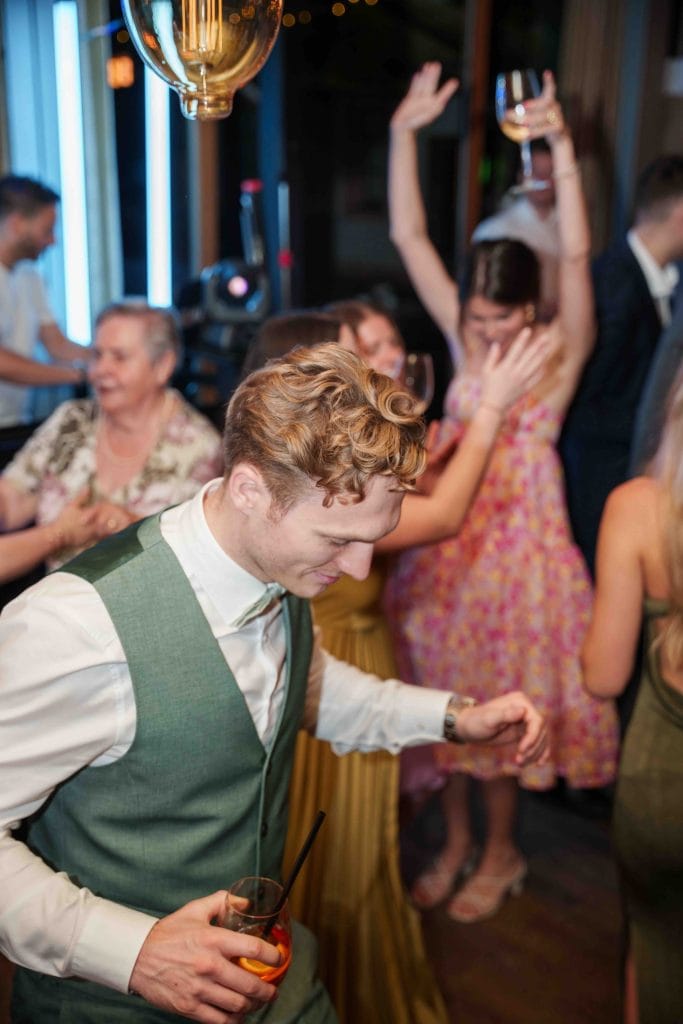 Feiernde Gäste bei einer Hochzeitsparty, tanzend und lachend in einer festlichen Umgebung.